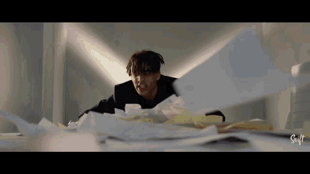 a man in a suit is laying on a pile of paper