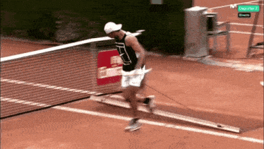 a man is running on a tennis court in front of a sign that says deportes 1