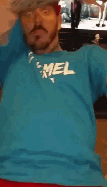 a man wearing a red hat and a blue shirt that says marcel on it