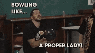 a man is holding a bowling ball in a bowling alley and says bowling like a proper lady .