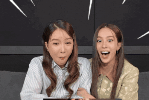 two women sitting next to each other with one wearing a striped shirt with the letter o on it