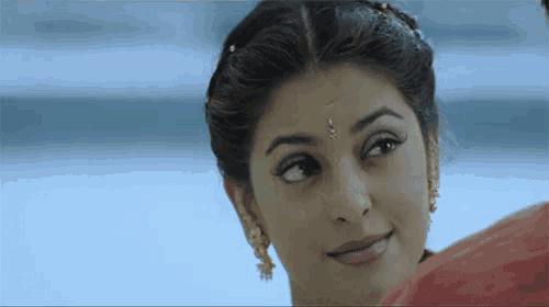 a woman with a bindi on her forehead looks at something