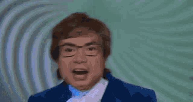 a man with glasses and purple hair is making a funny face .