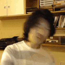 a blurry picture of a person standing in front of a bookshelf .