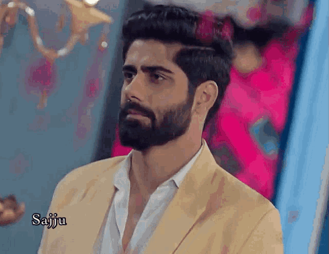 a man with a beard is wearing a yellow jacket and a white shirt