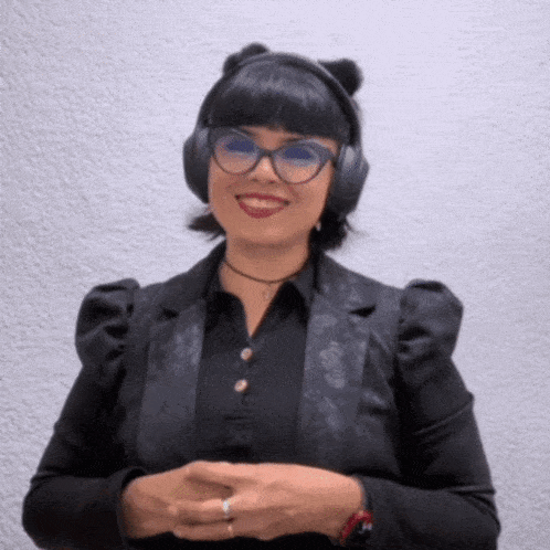 a woman wearing headphones and a black jacket smiles for the camera