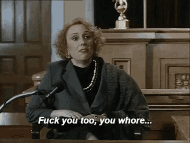 a woman sitting in front of a microphone with the words " fuck you too you whore "