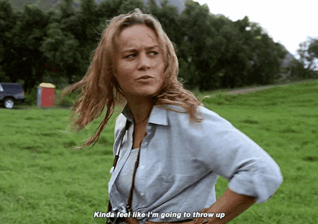 a woman standing in a grassy field says " kinda feel like i 'm going to throw up " .