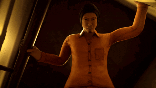 a man in an orange shirt and black hat is standing in the dark