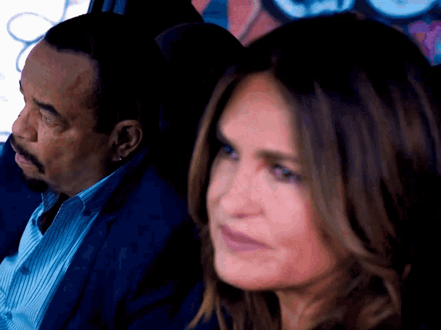 a man and a woman are sitting in a car and the woman is looking at the man