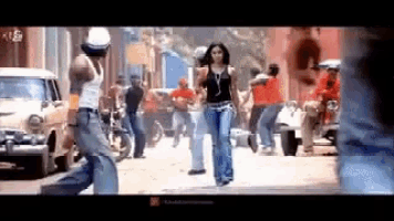 a man and a woman are walking down a street in a video .