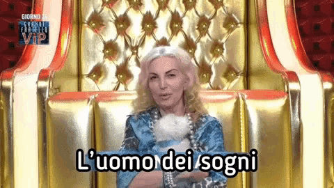 a woman is sitting in a chair with the words l' uomo dei sogni on the bottom