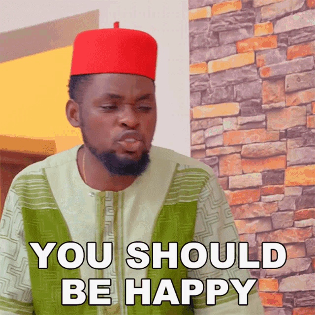 a man wearing a red hat and a green shirt says " you should be happy "