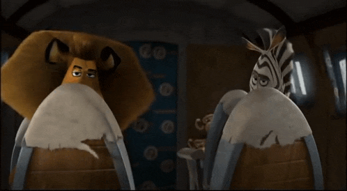 a zebra and a lion are standing next to each other and looking at each other