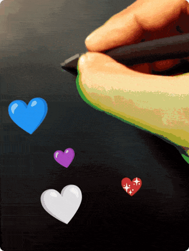 a person is drawing hearts on a black surface with a pen
