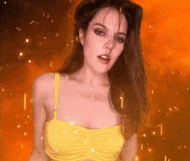 a woman in a yellow bikini top looks at the camera