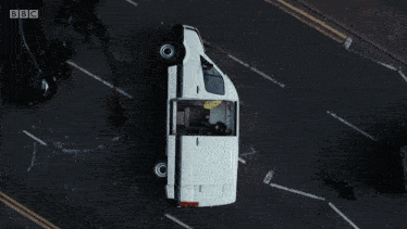 a white van is driving down a street with bbc written on the bottom