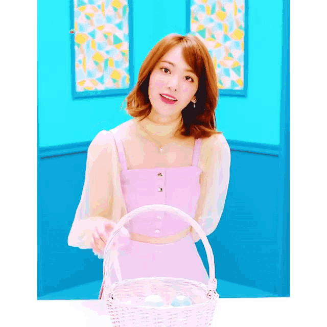 a woman in a pink dress is holding a white basket with eggs in it .