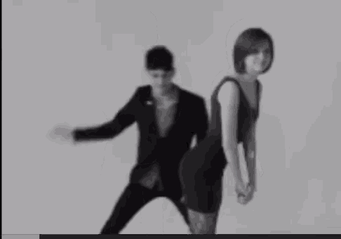 a black and white photo of a man and woman dancing