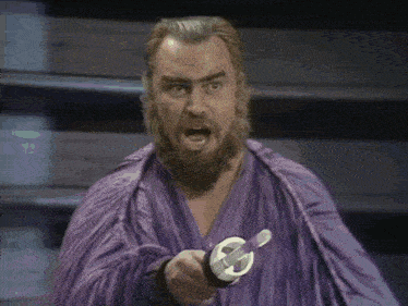 a man with a beard and a purple robe is holding a sword