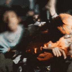 a blurry photo of a person wearing an orange sweater