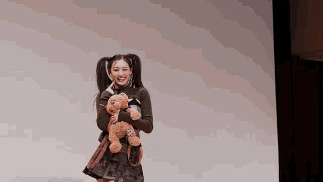 a woman holding a teddy bear in front of a screen that says 021:04 on it
