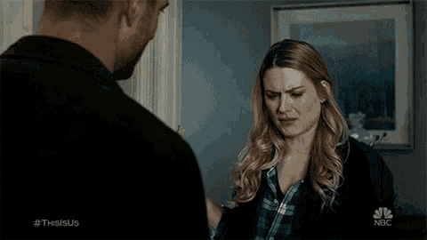 a man and a woman are standing next to each other in a living room .