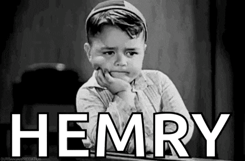 a little boy is sitting at a desk with his hand on his chin and the word hemry written on the screen .