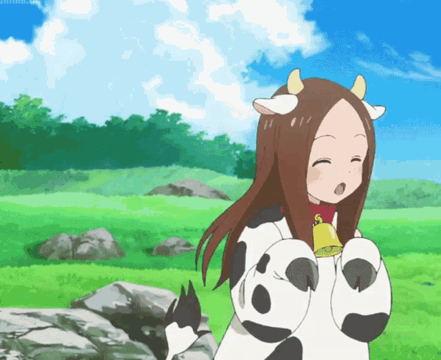 a girl in a cow costume holds a bell around her neck