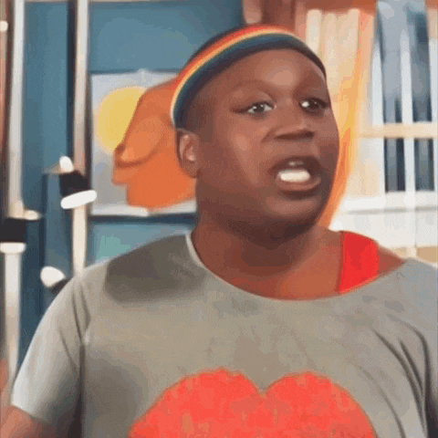 a man wearing a rainbow headband and a grey shirt is making a funny face .