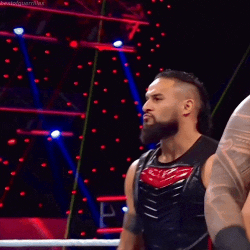 a man with a mohawk and a beard is standing in a ring .