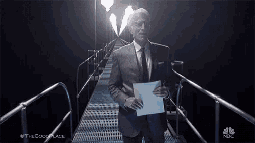 a man in a suit and tie is holding a piece of paper while walking down a metal walkway .