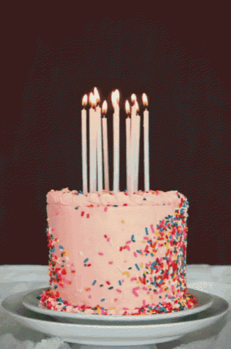 a birthday cake with candles and sprinkles on top