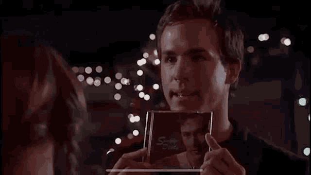a man is holding a cd with a picture of him on it .