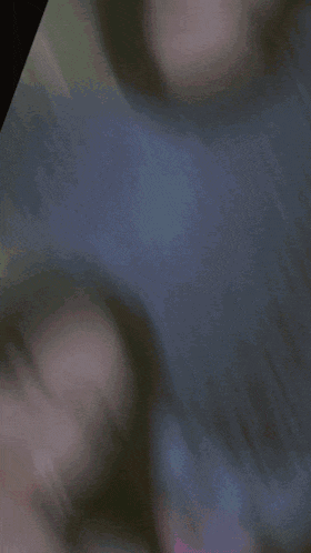 a blurred image of a woman 's face with a blue light coming out of her mouth