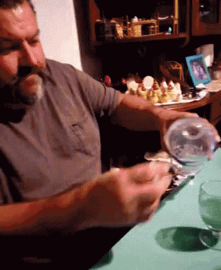 a man sitting at a table with a glass of water