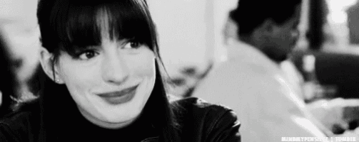 a black and white photo of a woman smiling in a restaurant .
