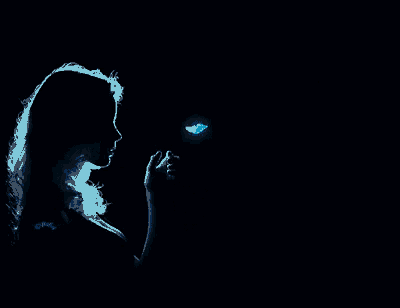 a woman is holding a blue butterfly in her hands in the dark
