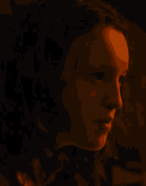 a close up of a woman 's face with a red light behind her