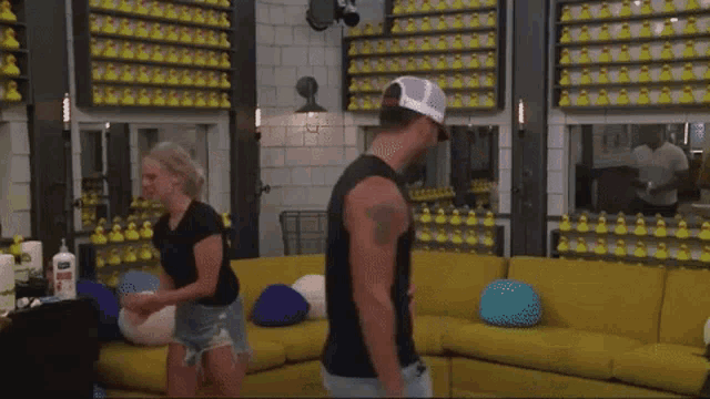 a man and a woman are dancing in a living room filled with rubber ducks