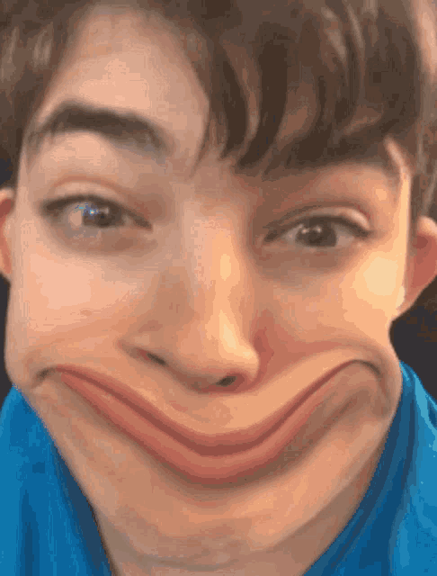 a young boy making a funny face with his mouth wide open