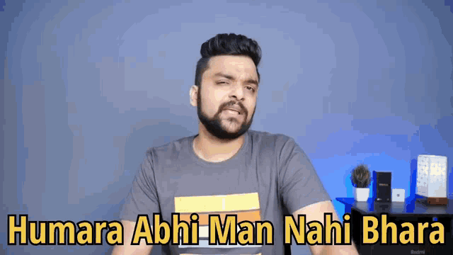 a man with a beard is wearing a t-shirt that says humara abhi man nahi bharat