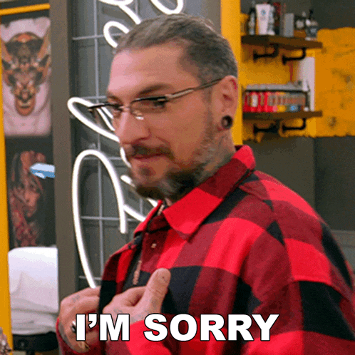 a man wearing glasses and a red plaid shirt says i 'm sorry