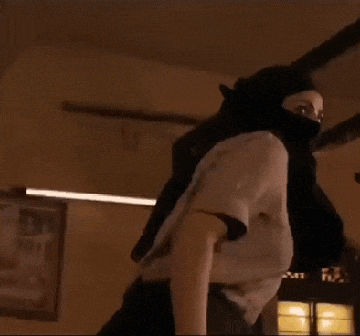 a woman is wearing a mask and standing in a room .