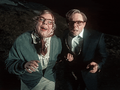 a man and a woman are standing next to each other and one of them is wearing glasses
