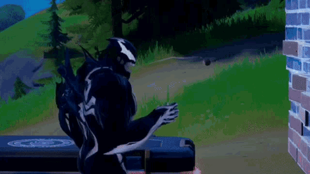 a man in a venom costume is standing in front of a brick wall in a video game .