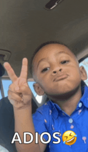 a young boy in a blue shirt is giving a peace sign with the word adios written below him