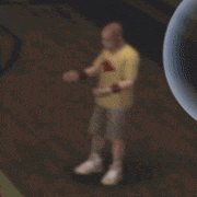 a man in a yellow shirt and shorts is standing in front of a bubble .
