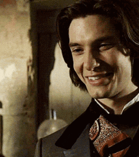 a man wearing a suit and tie is smiling for the camera