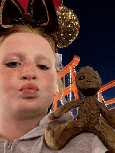 a girl holding a stuffed animal with a tag on it that says ' disney ' on it